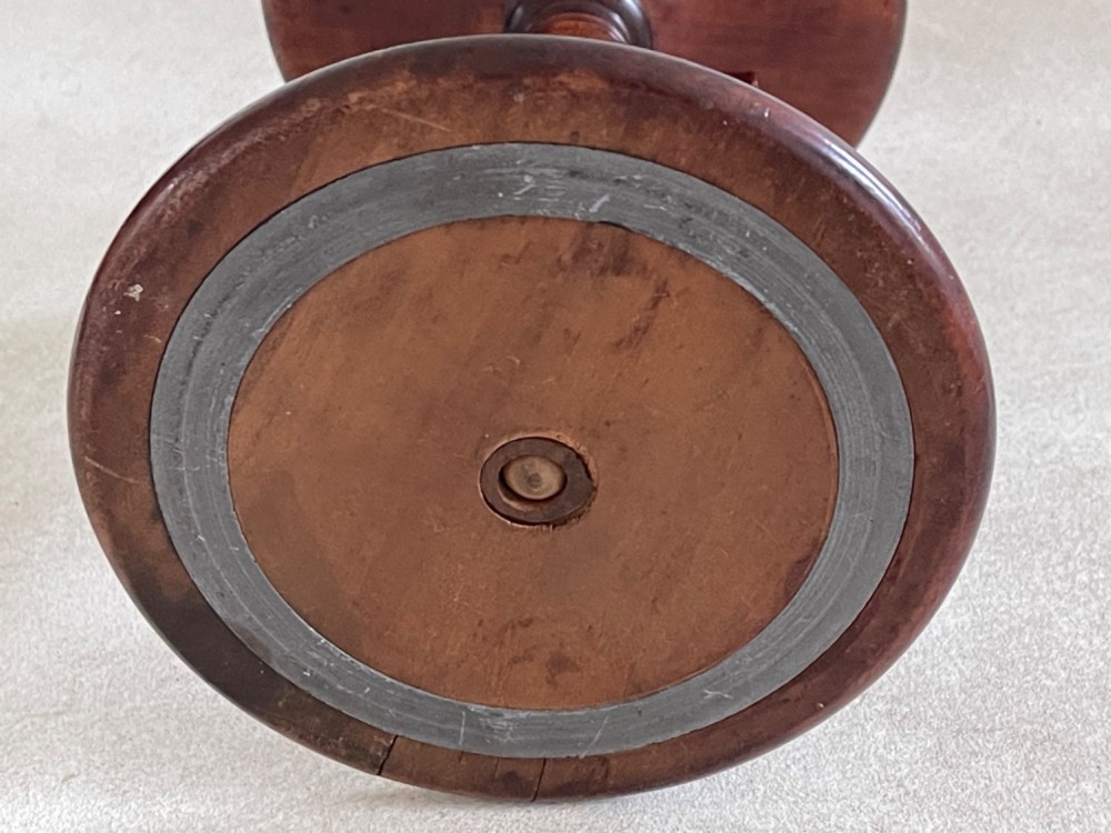 A dark turned mahogany Georgian candle stand featuring a height-adjustment screw mechanism, a dished circular top tray, and a wide circular base. View III