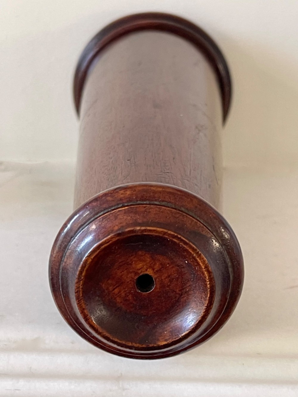 An upright turned dark mahogany wooden kaleidoscope with a tapered conical body and rounded moulded borders. View II