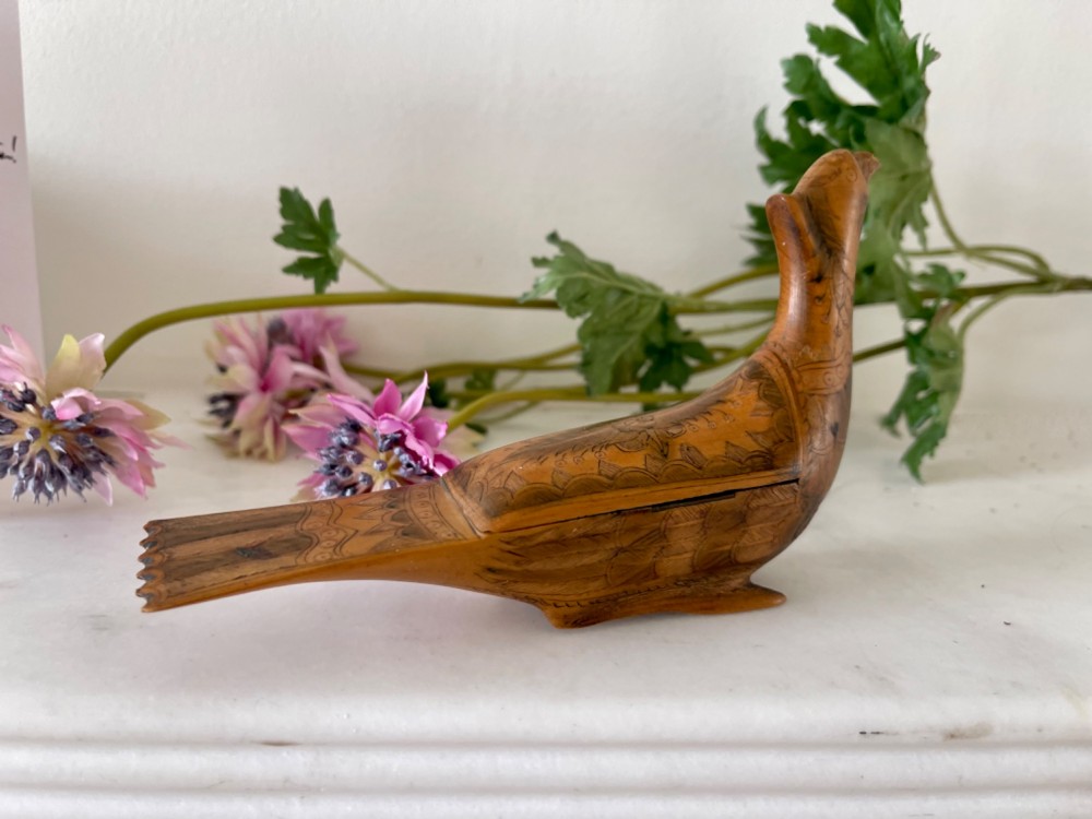 An antique hand-carved wooden snuff box shaped like a bird with incised feather detailing across the body. View II