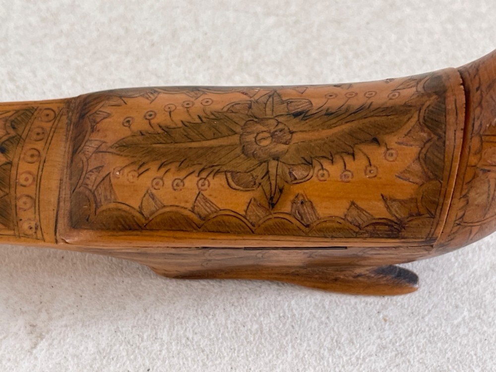 An antique hand-carved wooden snuff box shaped like a bird with incised feather detailing across the body. View III