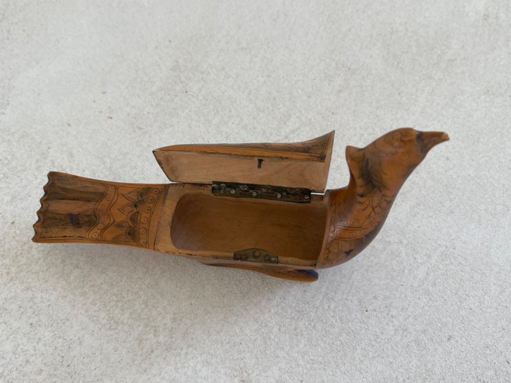 An antique hand-carved wooden snuff box shaped like a bird with incised feather detailing across the body. View IV
