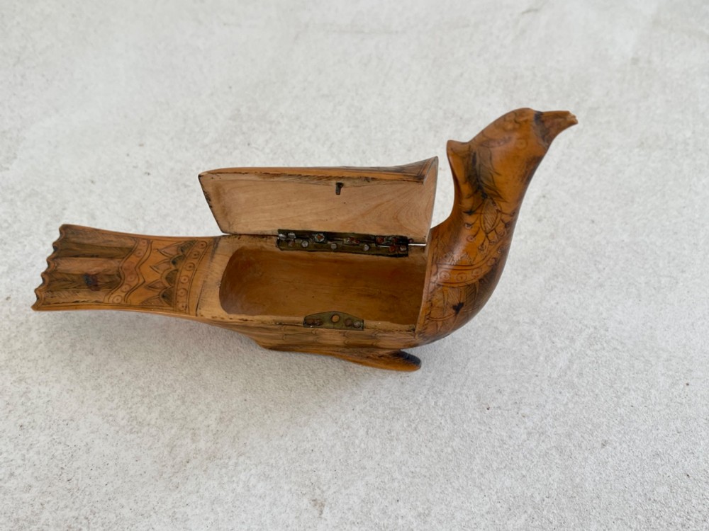 An antique hand-carved wooden snuff box shaped like a bird with incised feather detailing across the body. View V