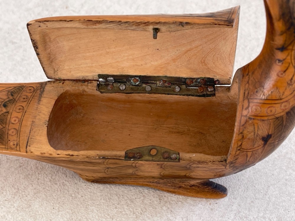 An antique hand-carved wooden snuff box shaped like a bird with incised feather detailing across the body. View VI