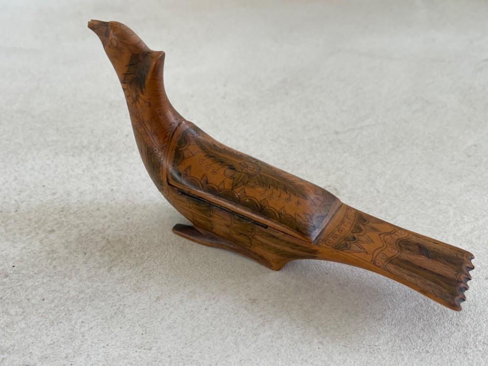 An antique hand-carved wooden snuff box shaped like a bird with incised feather detailing across the body. View VII