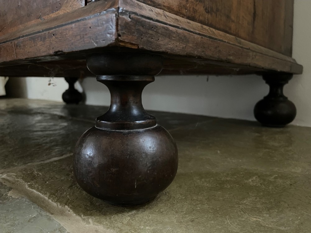 A late 17th-century walnut chest of drawers featuring brass teardrop handles, keyhole escutcheons, crossbanded veneer drawer fronts, and turned bun feet. View VIII