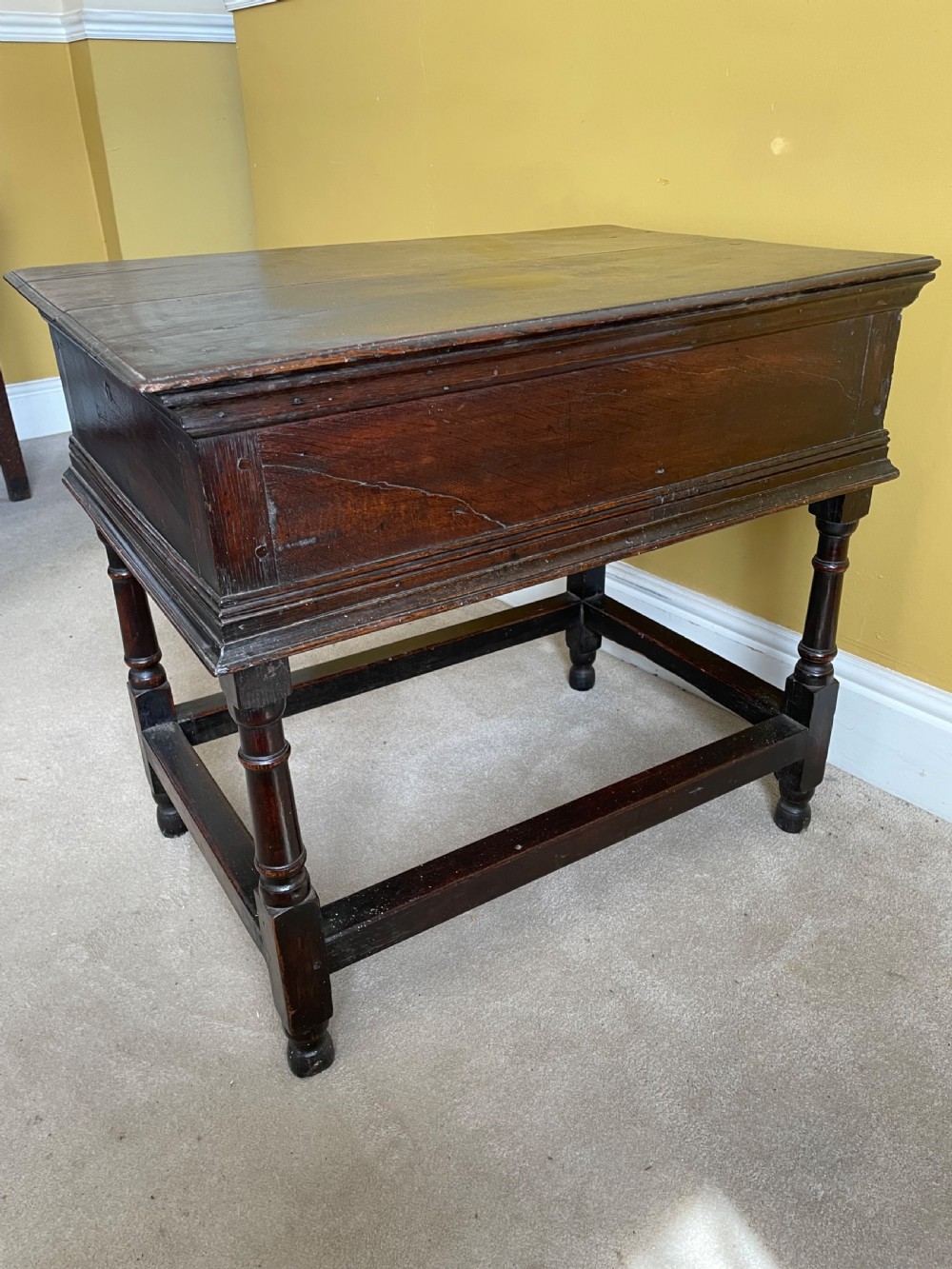 A 17th-century dark oak rent table featuring two frieze drawers with decorative brass handles, supported on turned legs with a rectangular perimeter stretcher. View V