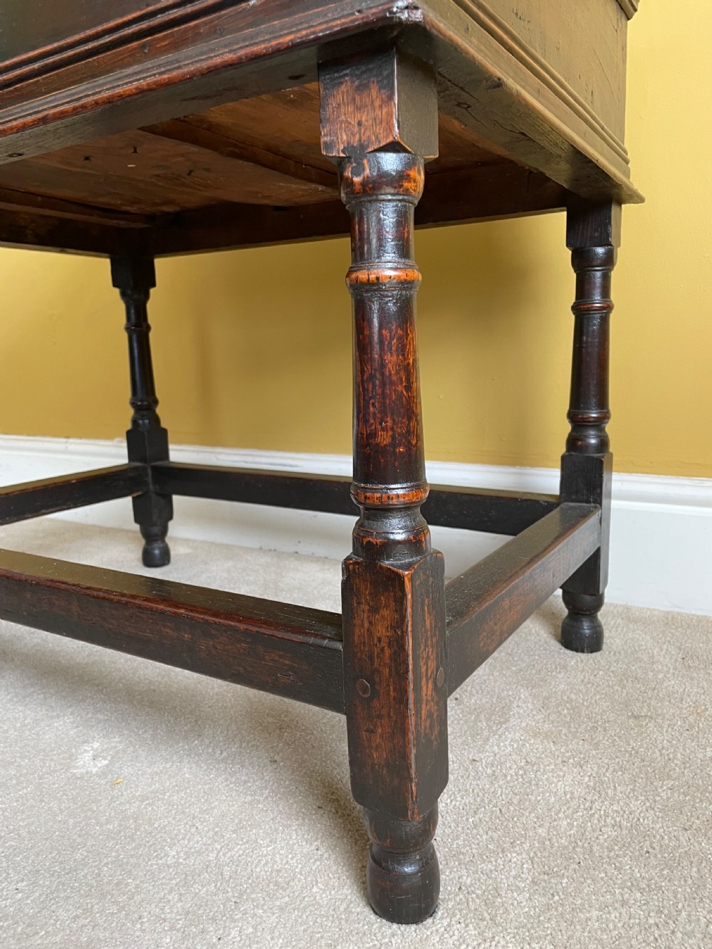 A 17th-century dark oak rent table featuring two frieze drawers with decorative brass handles, supported on turned legs with a rectangular perimeter stretcher. View X