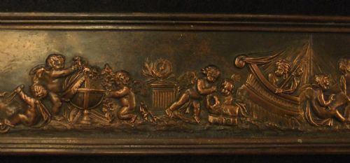 fig 2. A long horizontal dark bronze relief frieze featuring classical cherubs engaged in allegorical scenes set within a slender rectangular frame.