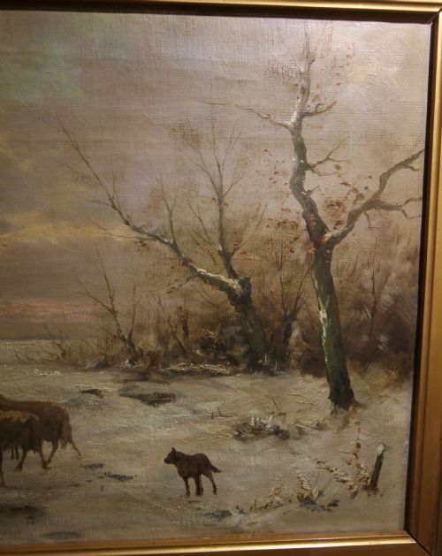 fig 2. A framed 19th-century oil painting depicting a shepherd leading a flock of sheep into a barn during a snowy winter landscape, housed in a gold gilt frame.