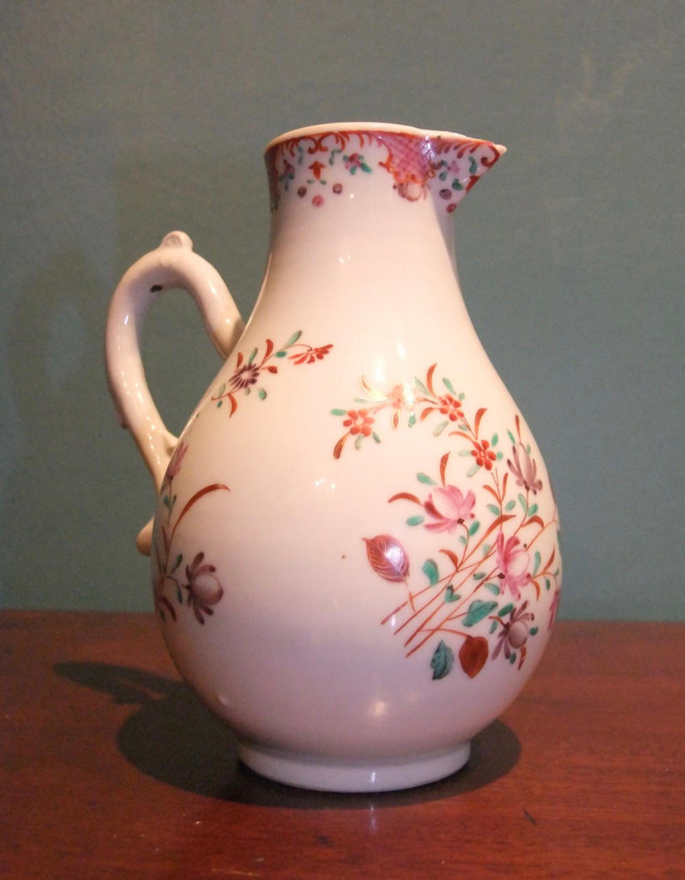 An 18th-century Chinese famille rose porcelain cream jug featuring a sparrow-beak spout and painted floral sprigs on a white ground.