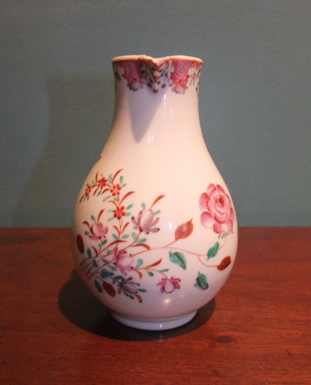 An 18th-century Chinese famille rose porcelain cream jug featuring a sparrow-beak spout and painted floral sprigs on a white ground. View II