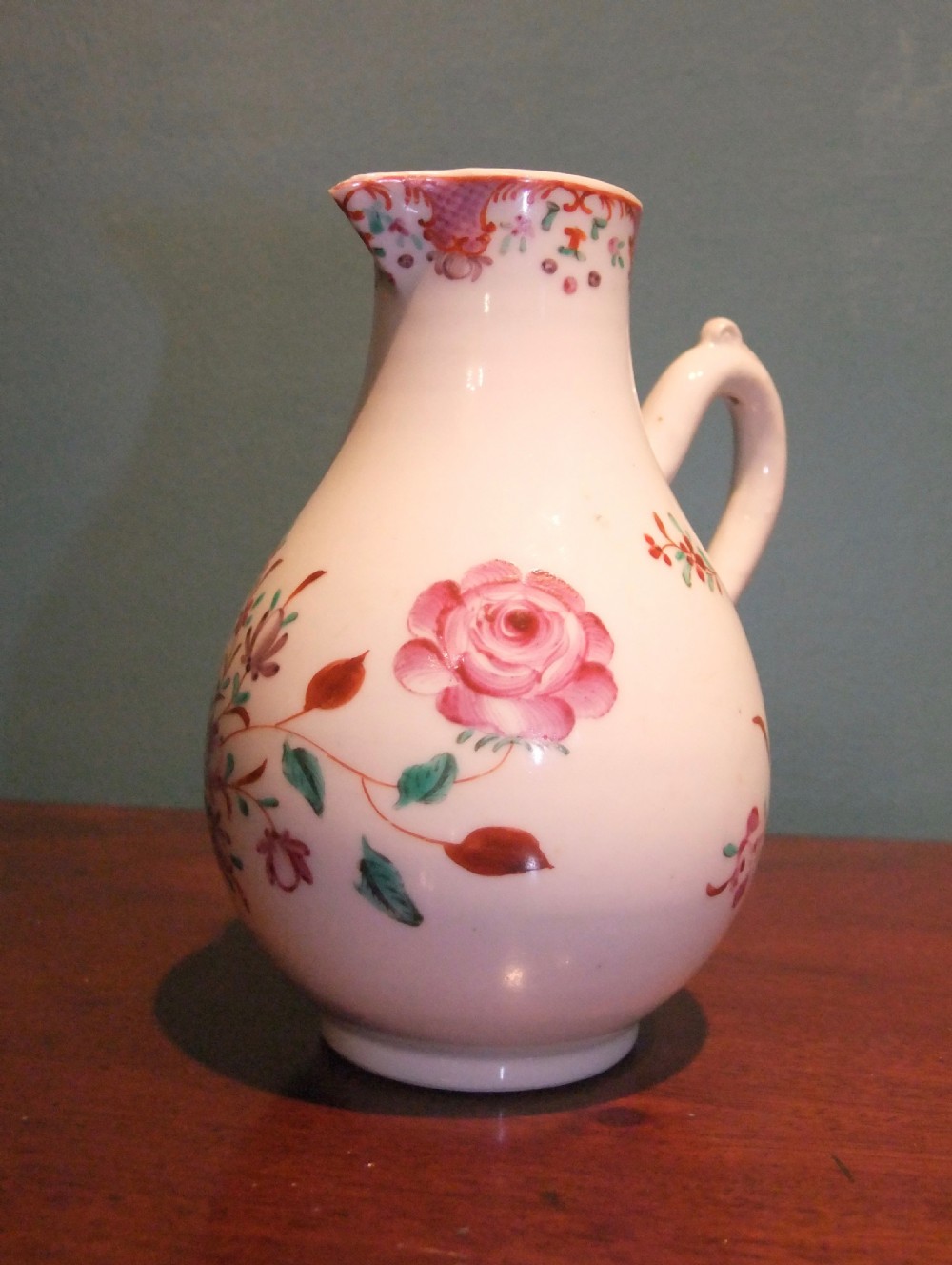 An 18th-century Chinese famille rose porcelain cream jug featuring a sparrow-beak spout and painted floral sprigs on a white ground. View III