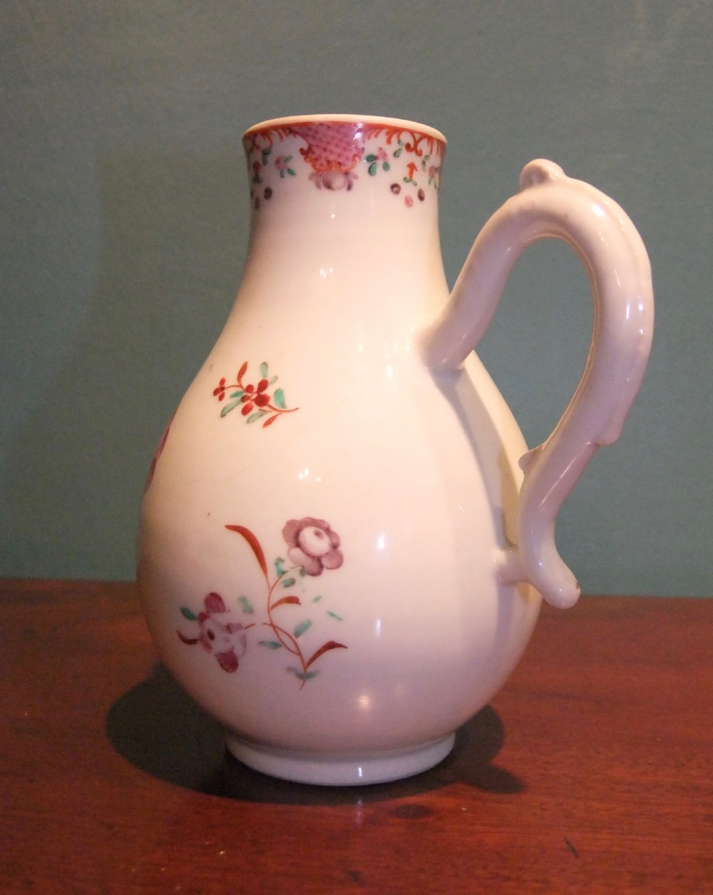 An 18th-century Chinese famille rose porcelain cream jug featuring a sparrow-beak spout and painted floral sprigs on a white ground. View IV