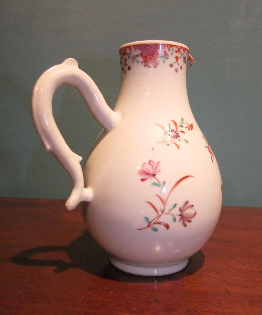 An 18th-century Chinese famille rose porcelain cream jug featuring a sparrow-beak spout and painted floral sprigs on a white ground. View V