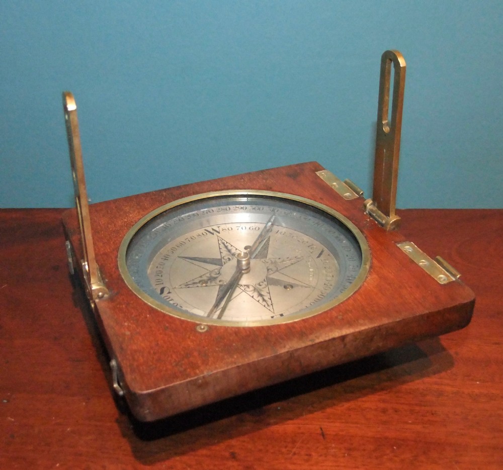 A circular Georgian brass and silvered compass rose with engraved degree markings housed in a square mahogany timber frame. View VI