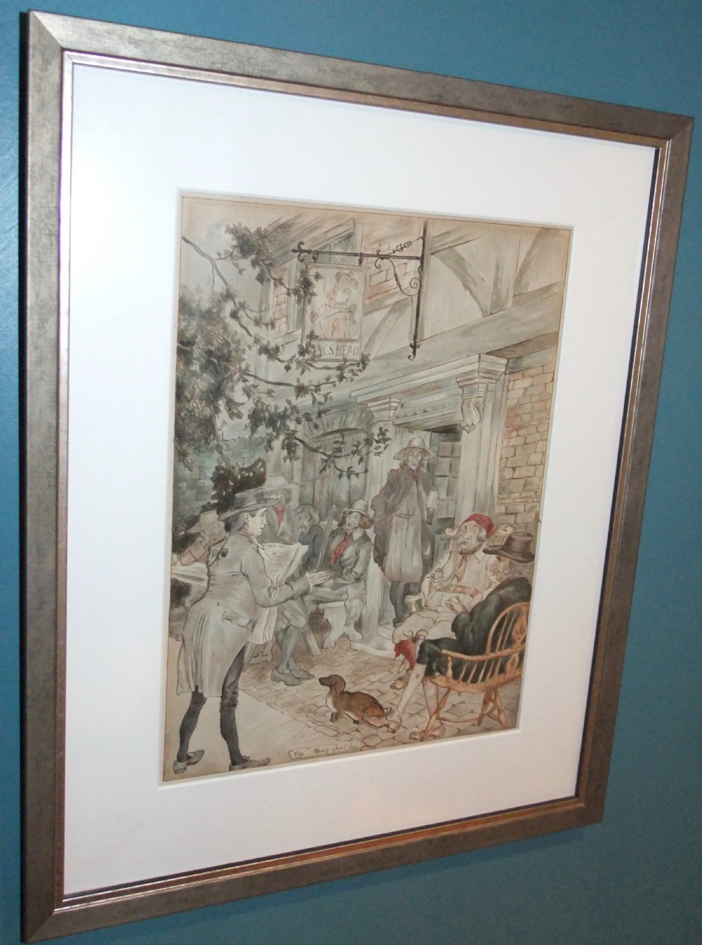 A framed 19th-century pen and ink drawing depicting figures gathered outside a tavern reading a news-sheet, set within a white mount and a silver-grey frame.