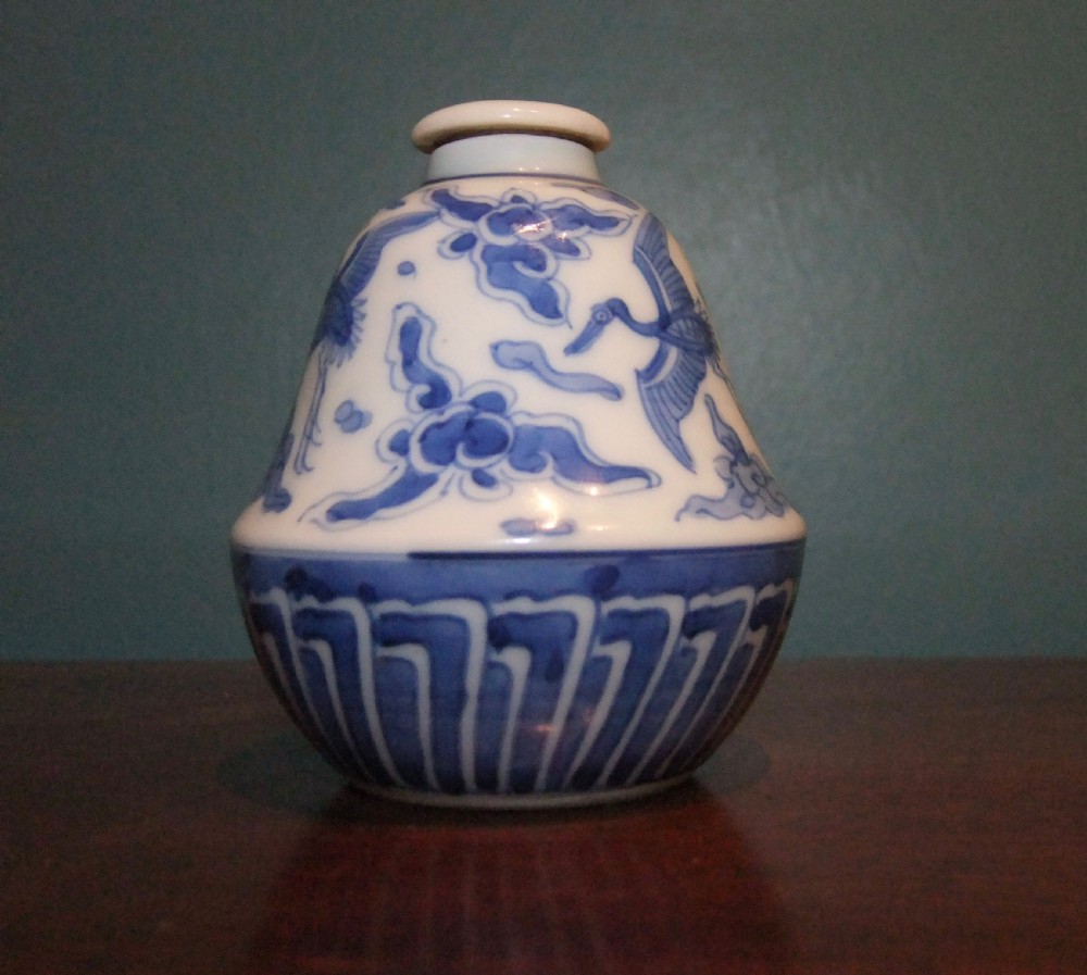 A small bell-shaped Chinese blue and white porcelain lidded bottle decorated with hand-painted flying cranes and cloud motifs. View VI