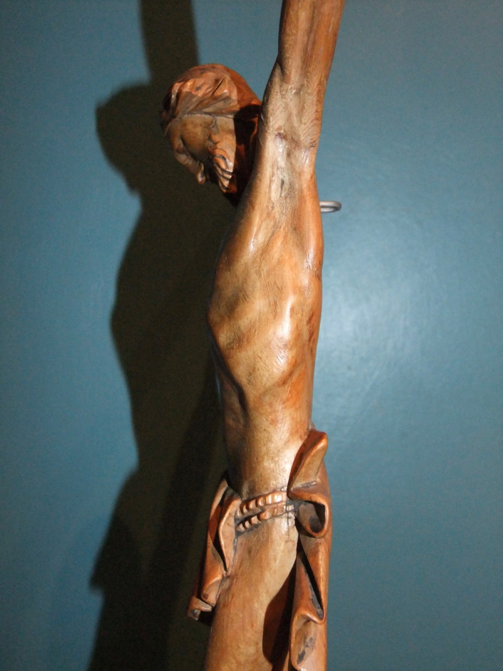 An 18th-century carved fruitwood figure of Corpus Christi showing anatomical detail and draped loincloth against a plain background. View X