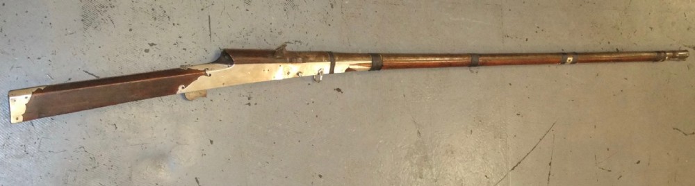 An early 18th-century Indian Toradar matchlock musket with an elongated dark wood stock, a long steel barrel, and metal lock plates.