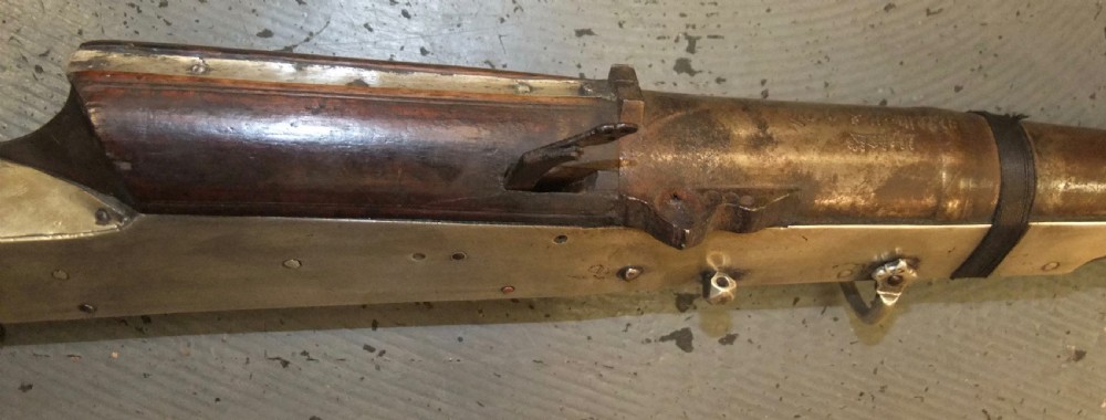 An early 18th-century Indian Toradar matchlock musket with an elongated dark wood stock, a long steel barrel, and metal lock plates. View VI