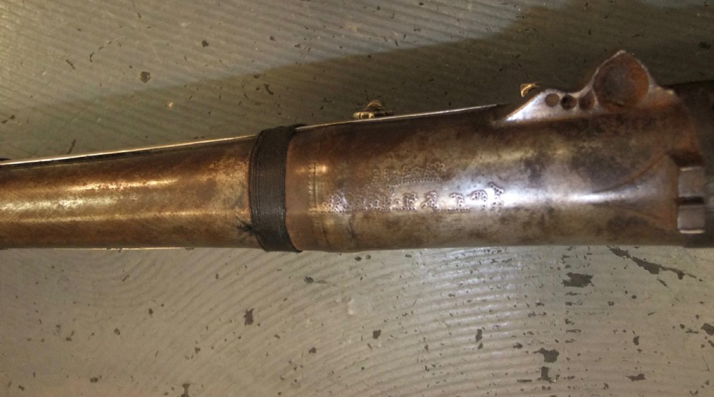 An early 18th-century Indian Toradar matchlock musket with an elongated dark wood stock, a long steel barrel, and metal lock plates. View VIII