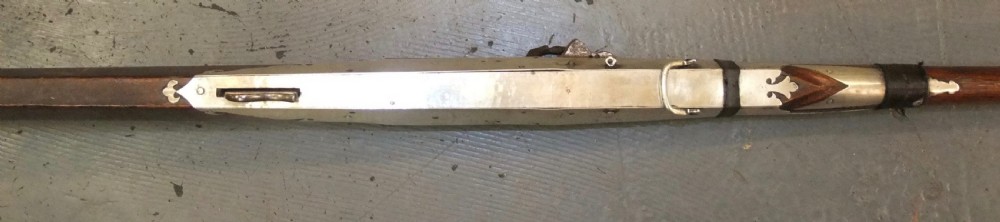 An early 18th-century Indian Toradar matchlock musket with an elongated dark wood stock, a long steel barrel, and metal lock plates. View XI