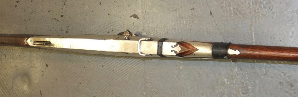 An early 18th-century Indian Toradar matchlock musket with an elongated dark wood stock, a long steel barrel, and metal lock plates. View XII