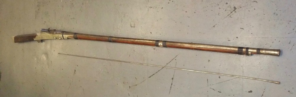 An early 18th-century Indian Toradar matchlock musket with an elongated dark wood stock, a long steel barrel, and metal lock plates. View XV