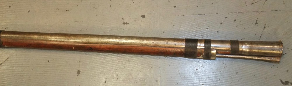 An early 18th-century Indian Toradar matchlock musket with an elongated dark wood stock, a long steel barrel, and metal lock plates. View XVII