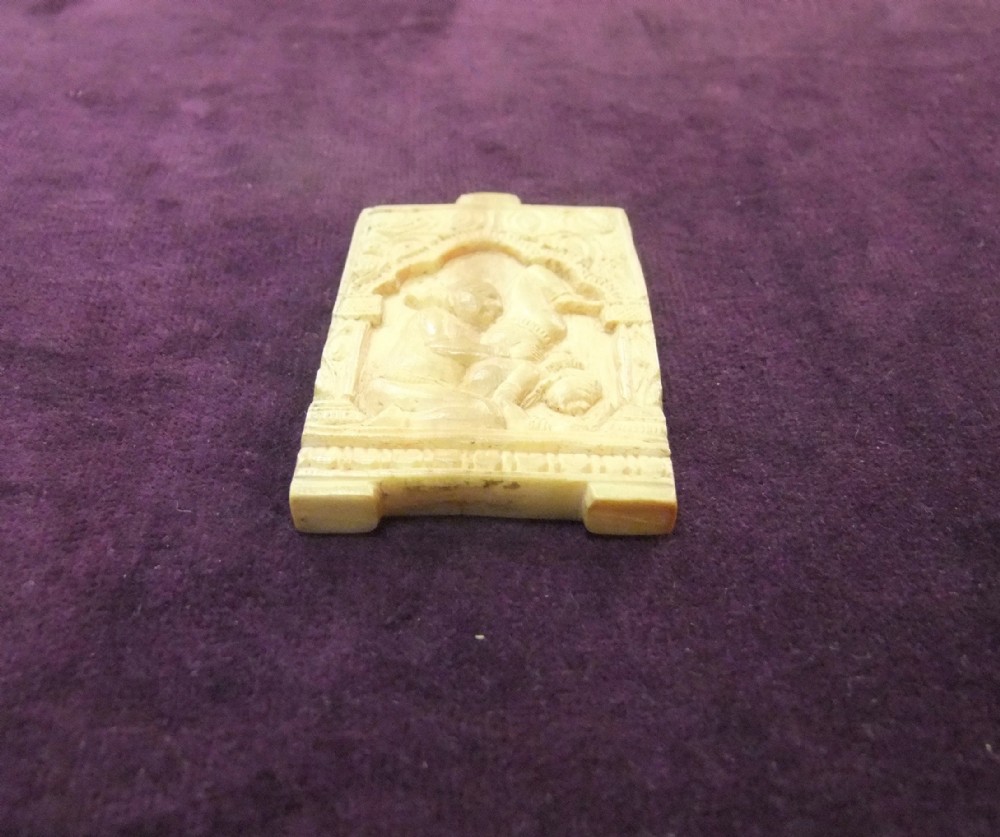 An 18th-century cream-coloured carved relief panel depicting figures within an architectural arch.