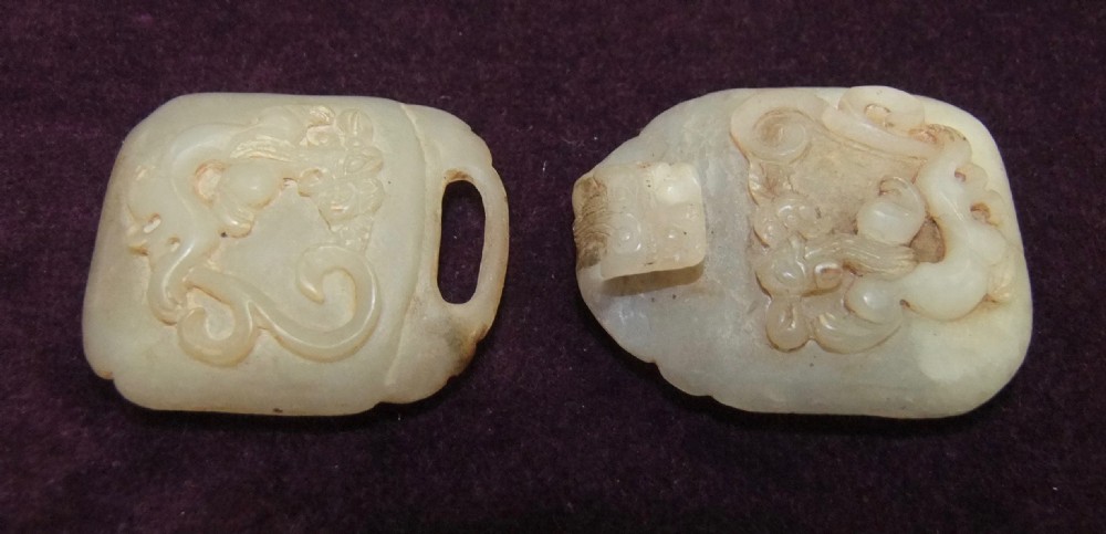 A two-part carved off-white jade belt buckle featuring raised dragon reliefs and an interlocking loop mechanism. View II