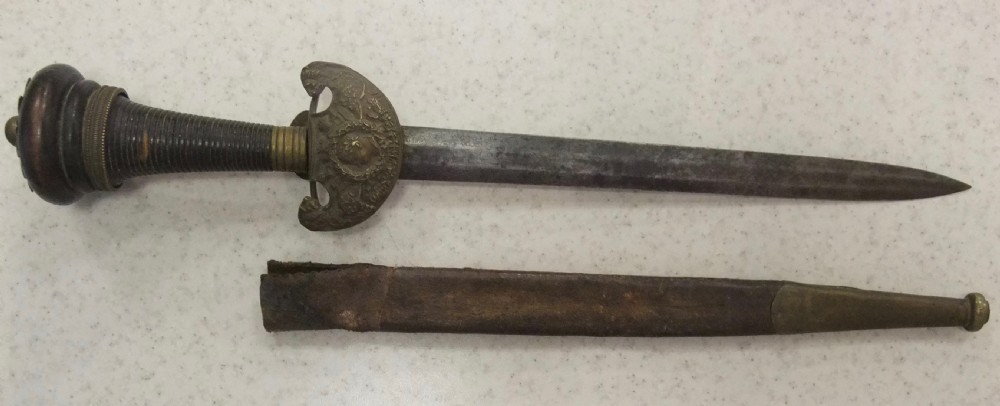 An antique French Napoleonic naval dagger with a tapered steel blade, ornate brass guard, turned dark grip, and leather scabbard.