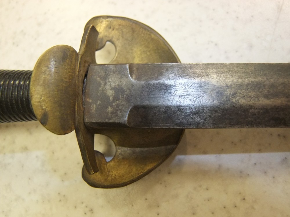 An antique French Napoleonic naval dagger with a tapered steel blade, ornate brass guard, turned dark grip, and leather scabbard. View VIII