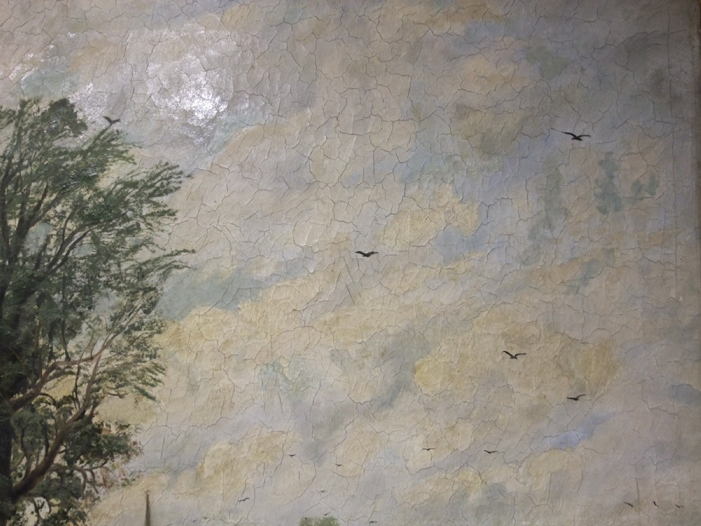 A large 19th-century oil painting depicting cattle drinking at a shallow river ford beneath tall mature trees near a distant village. View VI