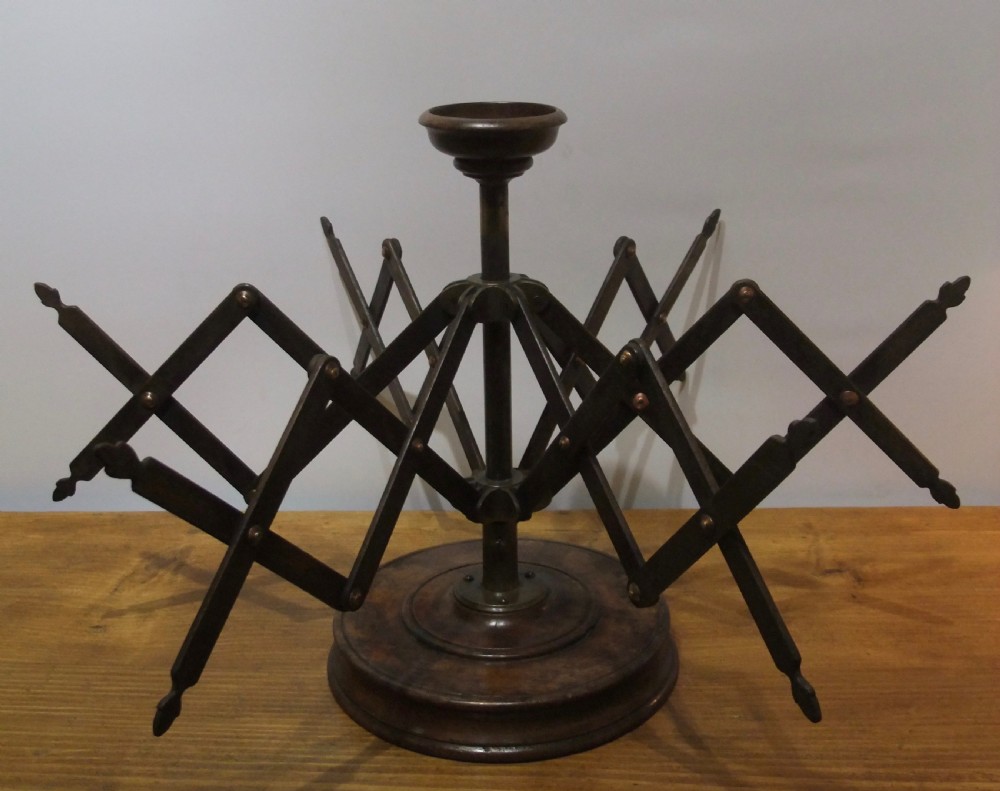 A Victorian dark mahogany table-top wool winder with an adjustable concertina lattice frame mounted on a turned circular base.