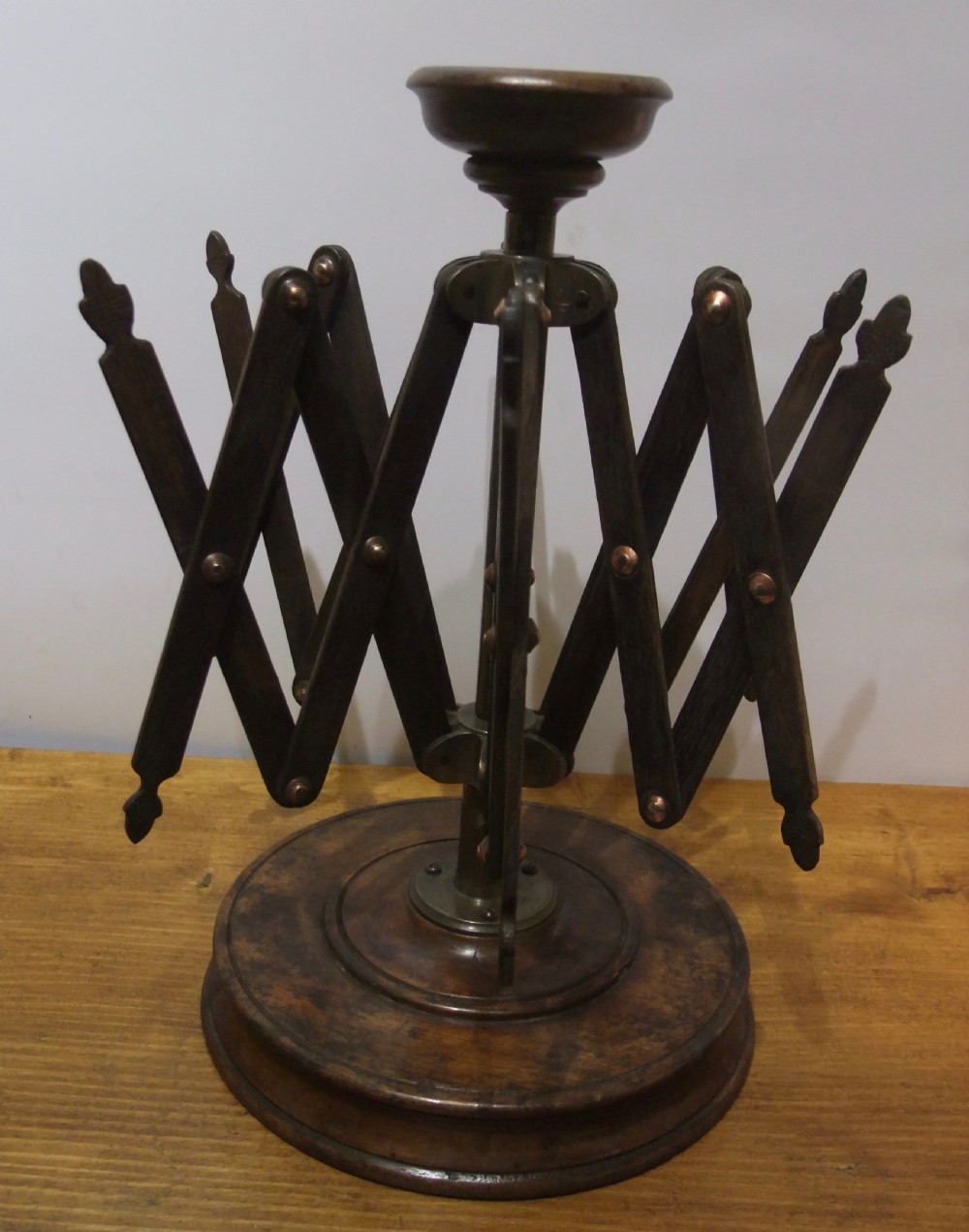A Victorian dark mahogany table-top wool winder with an adjustable concertina lattice frame mounted on a turned circular base. View II