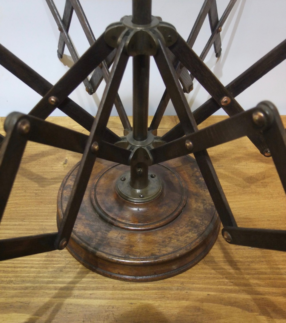 A Victorian dark mahogany table-top wool winder with an adjustable concertina lattice frame mounted on a turned circular base. View V