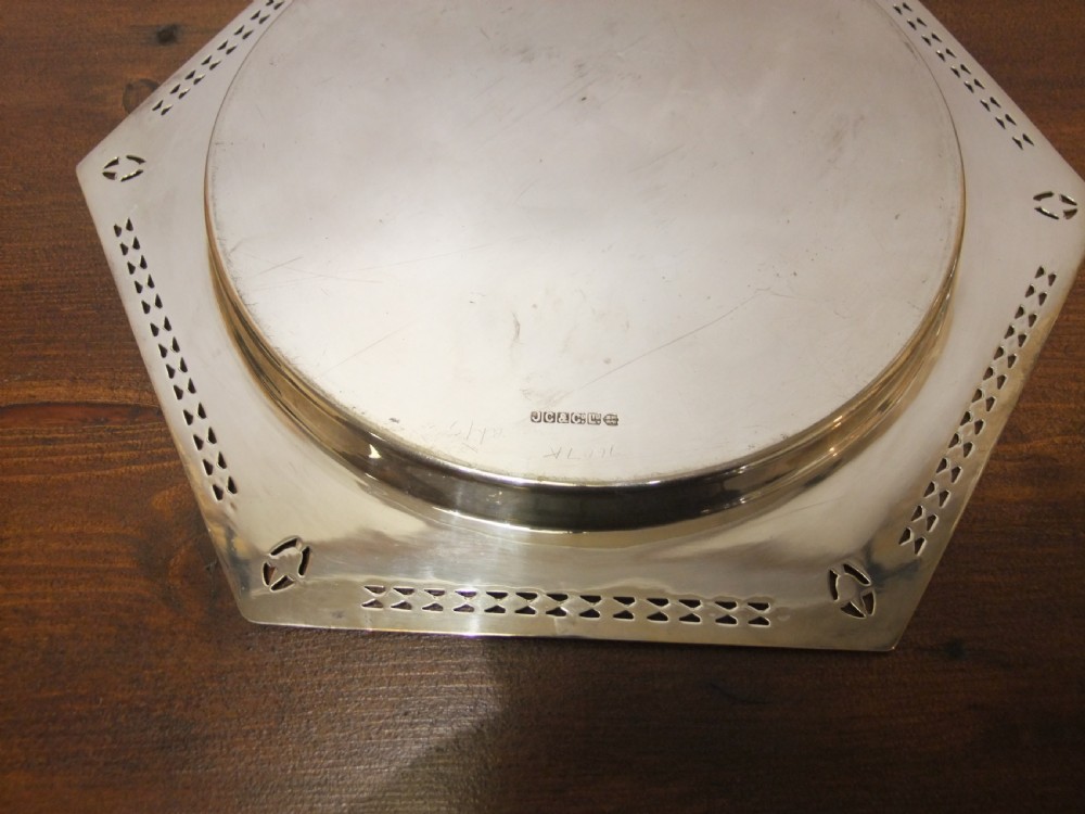 A hexagonal silver-plated dish featuring a circular central recess and pierced geometric borders around the outer rim. View IV