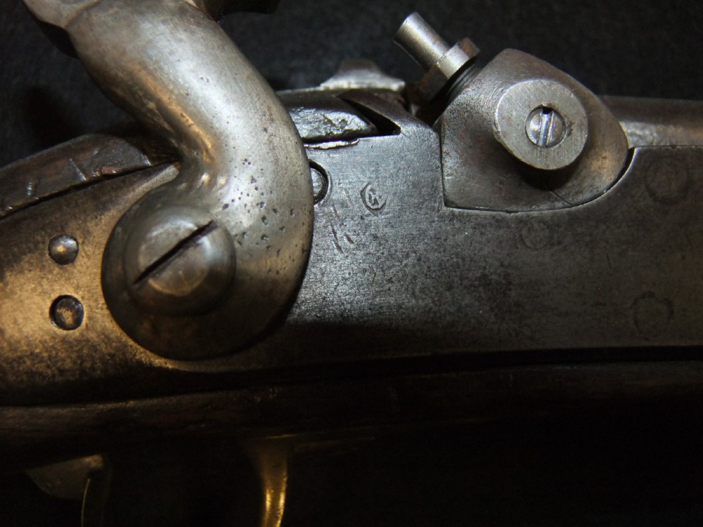 A mid-19th-century French percussion carbine featuring a dark walnut stock, brass fittings, a steel barrel, and an attached socket bayonet against a black background. View V