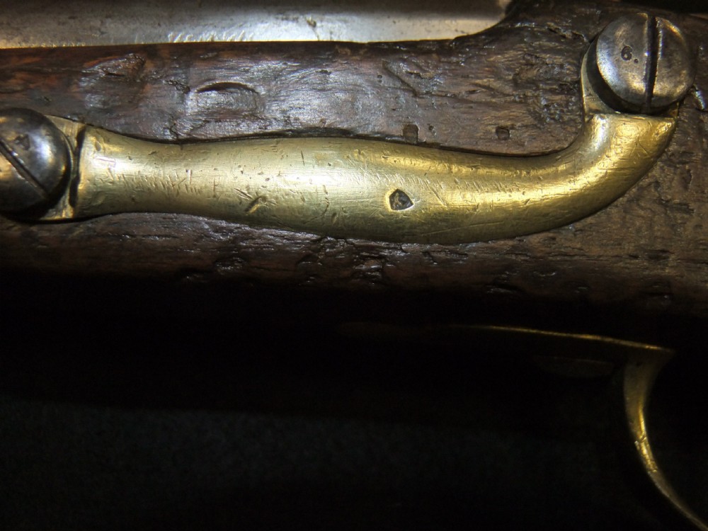 A mid-19th-century French percussion carbine featuring a dark walnut stock, brass fittings, a steel barrel, and an attached socket bayonet against a black background. View X