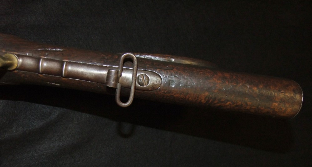 A mid-19th-century French percussion carbine featuring a dark walnut stock, brass fittings, a steel barrel, and an attached socket bayonet against a black background. View XVI