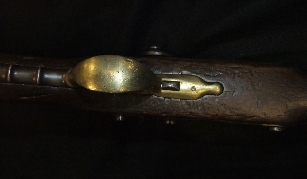 A mid-19th-century French percussion carbine featuring a dark walnut stock, brass fittings, a steel barrel, and an attached socket bayonet against a black background. View XVII