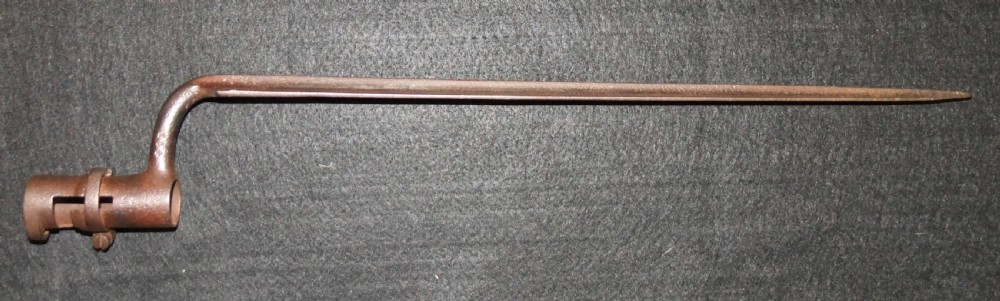 A mid-19th-century French percussion carbine featuring a dark walnut stock, brass fittings, a steel barrel, and an attached socket bayonet against a black background. View XX