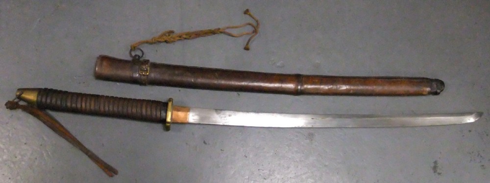 A Japanese WWII officers Shin-Gunto katana featuring a leather-wrapped scabbard, ribbed handle, and brass tsuba. View II