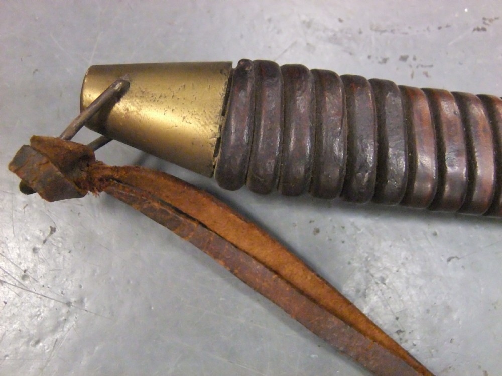 A Japanese WWII officers Shin-Gunto katana featuring a leather-wrapped scabbard, ribbed handle, and brass tsuba. View VI