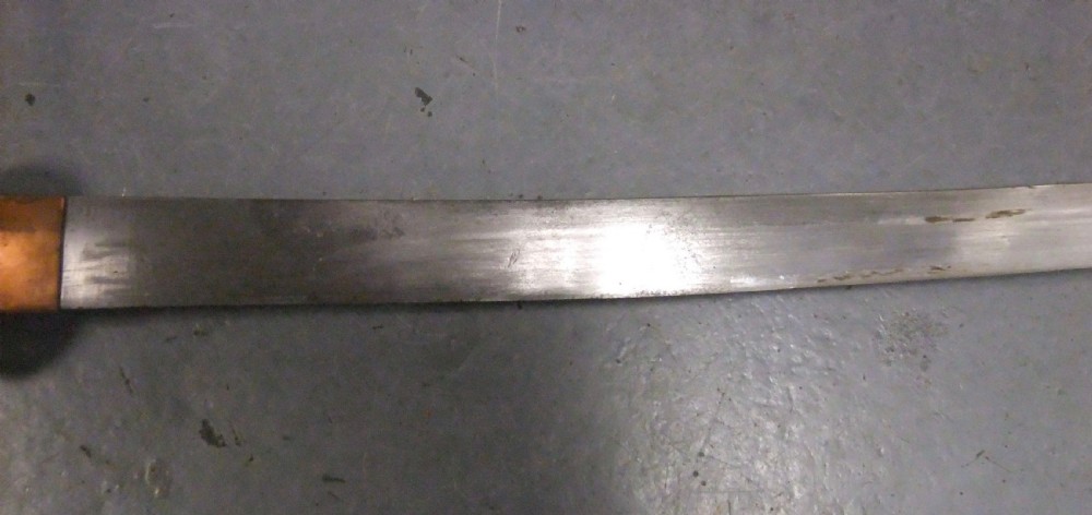 A Japanese WWII officers Shin-Gunto katana featuring a leather-wrapped scabbard, ribbed handle, and brass tsuba. View X