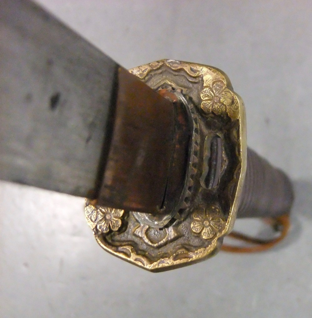 A Japanese WWII officers Shin-Gunto katana featuring a leather-wrapped scabbard, ribbed handle, and brass tsuba. View XV