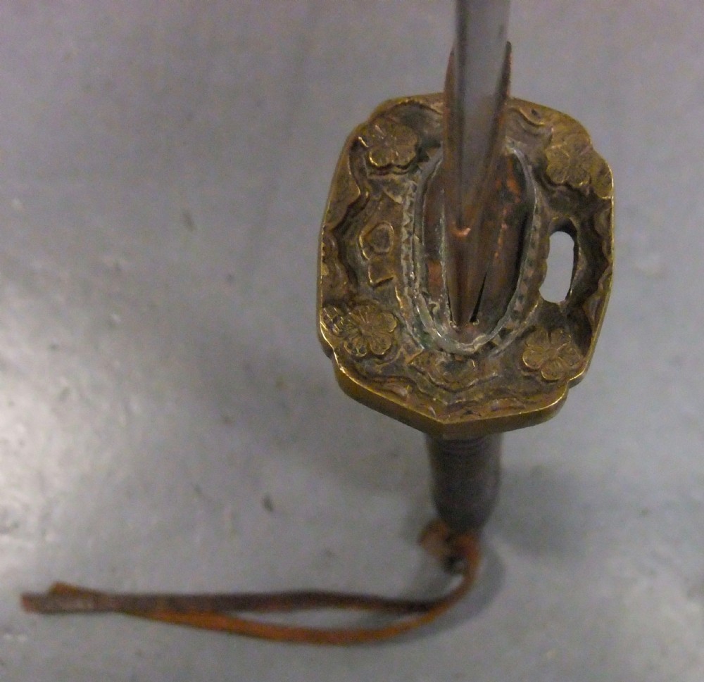 A Japanese WWII officers Shin-Gunto katana featuring a leather-wrapped scabbard, ribbed handle, and brass tsuba. View XVI