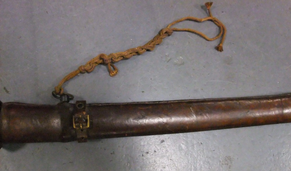 A Japanese WWII officers Shin-Gunto katana featuring a leather-wrapped scabbard, ribbed handle, and brass tsuba. View XXI