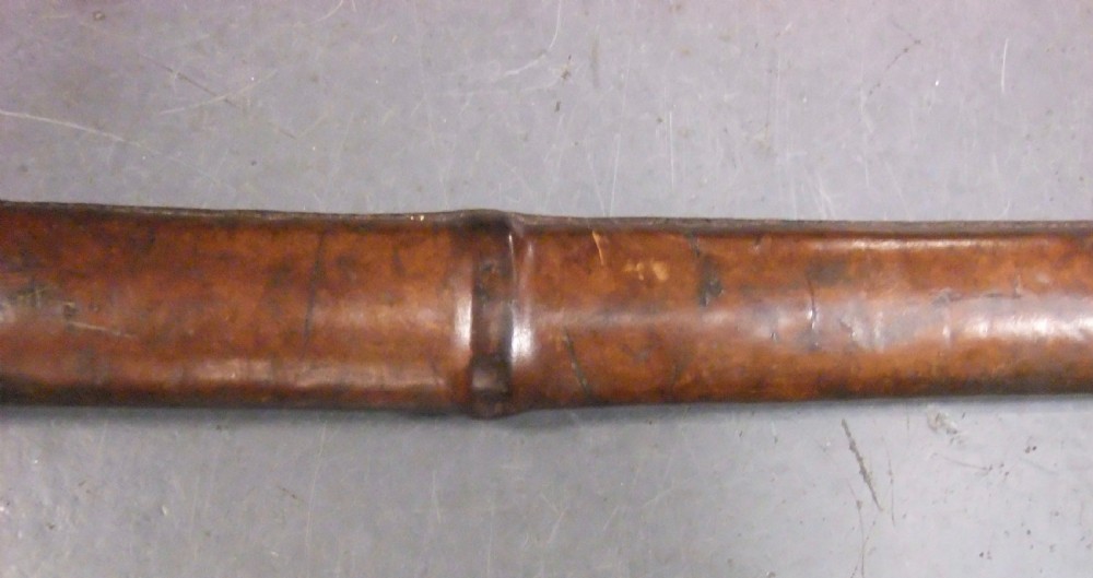 A Japanese WWII officers Shin-Gunto katana featuring a leather-wrapped scabbard, ribbed handle, and brass tsuba. View XXIV
